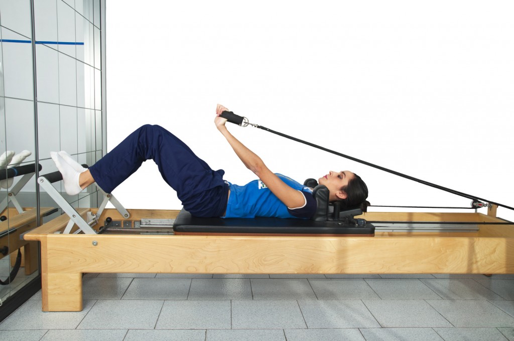 young girl performs exercises with pilates gear